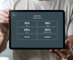 a server with an ipad showing tipping percentages to a customer