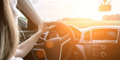 A woman driving a car, focused on the road ahead.