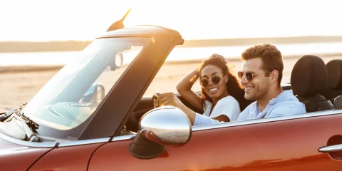 A couple enjoying a scenic drive in a convertible car