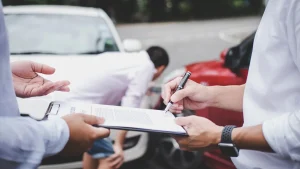 A person signing a document handed to them by another person