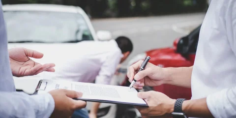 A person signing a document handed to them by another person