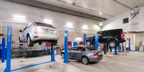 A car in a repair shop, getting ready to be fixed after a breakdown or damage