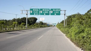 A road in Mexico with signs pointing to Mérida, Valladolid, and Holbox