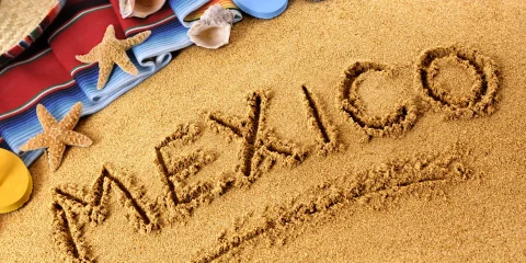 The word 'Mexico' beautifully written in the sand on a beach