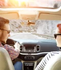 Two people inside their car having a conversation while on a road trip.