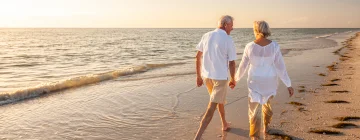 A couple happily walking down a mexican beach