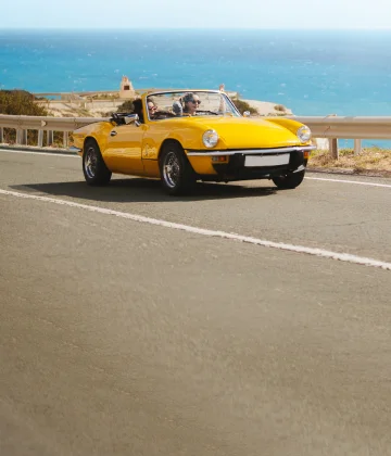 View of a car driving along the scenic Mexican coastline, ensuring a safe journey with reliable Mexican car insurance