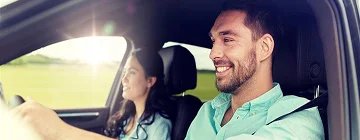 A happy couple driving on a road excited for the trip